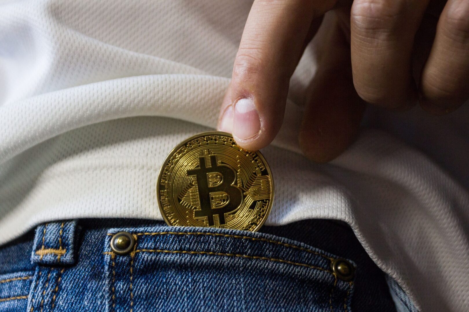 A person is holding onto a coin in their pocket.