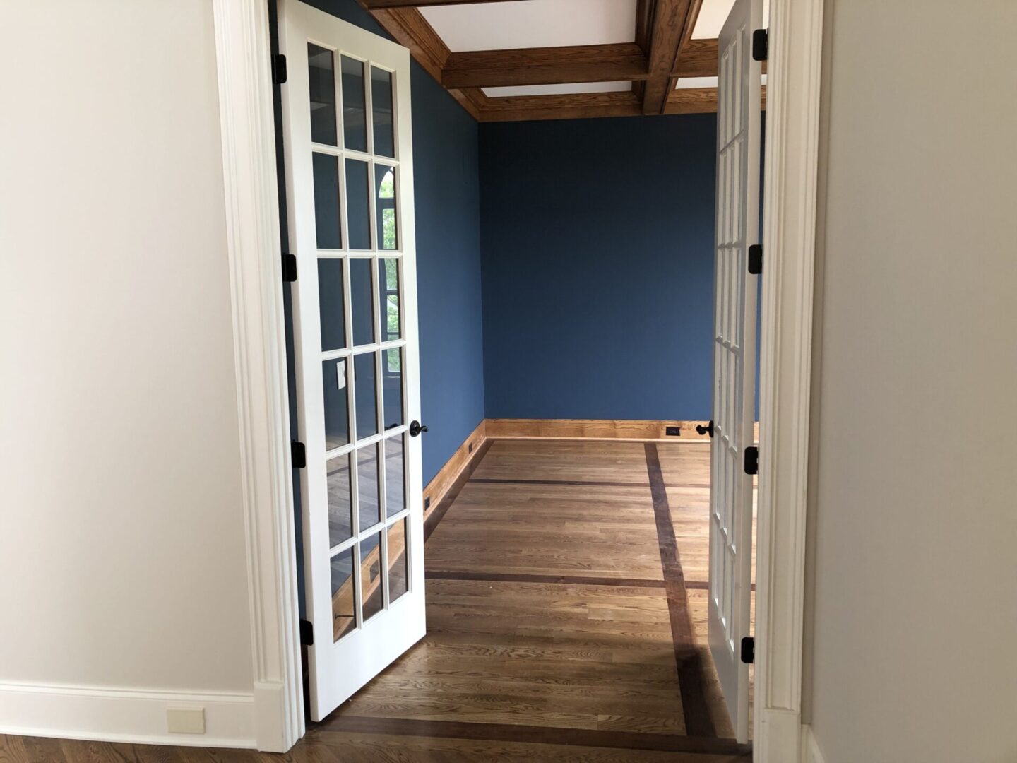 A door way with wood floors and blue walls.